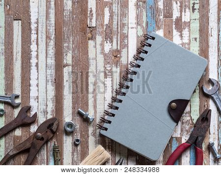 Blank Space Cover Note Book And Old Rusty Handy Working Tools On Gruge Wooden Background. Top View. 