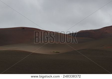 Timanfaya National Park, Lanzarote, Canary Islands, Spain. Red Mountains In The Distance. Clear Blue
