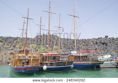 Many Wooden Ships On Port Of Nea Kameni Volcanic Island Near Santorini