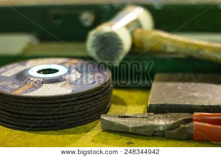 Wheels For Manual Circular Saw, Hammer And Pliers Unfocused In The Workroom
