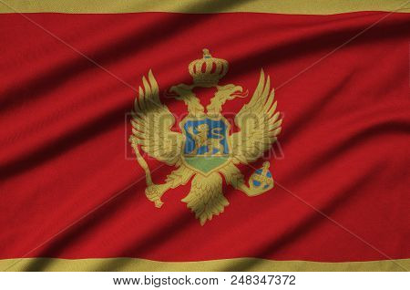 Montenegro Flag  Is Depicted On A Sports Cloth Fabric With Many Folds. Sport Team Waving Banner