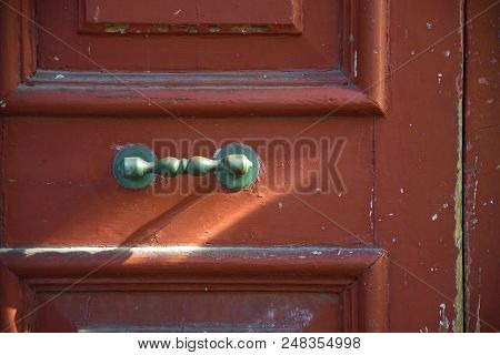 Photo Of A Door Detail With Red Colour, Wood Texture And Sunlight