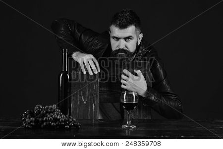 Winetasting And Degustation Concept. Sommelier Leans On Wooden Chair. Man With Beard Near Glass Of W