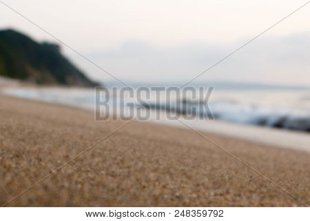 Nice Blurred Defocused Evening View Of Beach And Sea Waves. Calm And Peaceful Mood