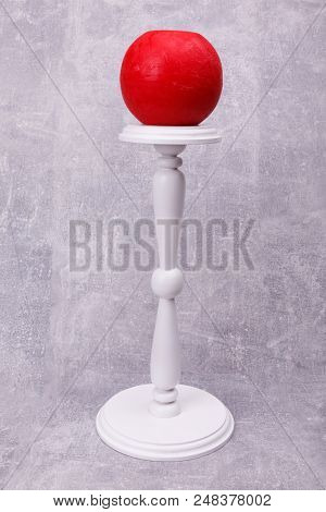 An Original White Candlestick With Catved Leg Is Situated On The Grey Background.