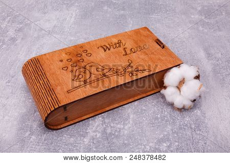A Carved Wooden Casket With Cute Images Is Decorated With Pussy-willow, Lying On The Grey Background
