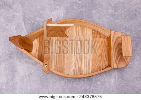 A Wooden Tray In The Form Of A Ship With Sails And Oar Is Situated On The Gre Background.