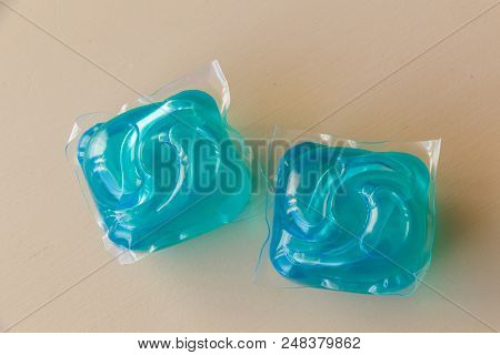 Two Doses Of Blue Liquid Detergent On A Table
