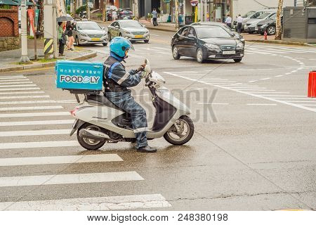 Seoul, South Korea; July 2, 2018: Unidentified Food Delivery Person In Rain Gear On A Motorcycle At 