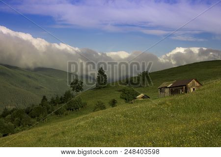 Photo Of Mountain Village In The Summer Under Beautiful Cloudy Sky. Ukraine, Carpathians, Dzembronia