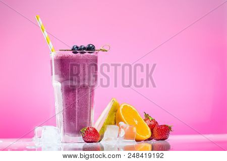 Delicious Smoothie With Drinking Straw In High Ball. Strawberries And Sliced Orange Near The High Ba