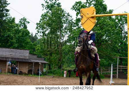 Cavalryman Ride On Beautiful Brown Horse At A Race Track For Horses. Old House In The Background, Fo