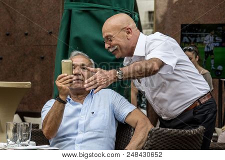 Belgrade, Serbia - June 14, 2015: Two Old Sernior White Men Sitting In A Cafe Looking At An Apple Ip