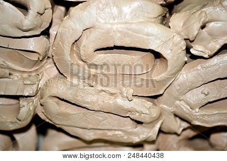 Wet White Clay Closeup. Abstract Pieces Of Wet Clay On The Table. Sculptor Sculpts Pots Products Fro