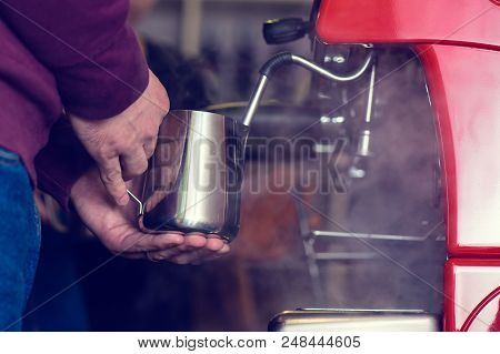 Professional Man Barista Preparing Fresh Coffee, Holding Pitcher For Steaming Milk. Preparation And 