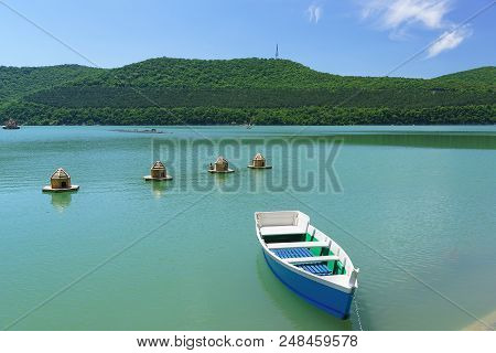Bright Blue Rowing Boat On The Emerald Water Of The Mountain Lake Abrau-durso