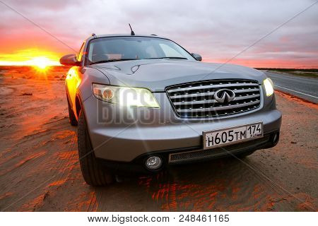 Novyy Urengoy, Russia - July 1, 2018: Grey Crossover Infiniti Fx35 At The Countryside At The Backgro