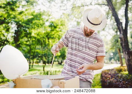 Photo Theme Small Business Cooking Sweets. A Young Man With A Beard Of A Caucasian Trader In The Hat