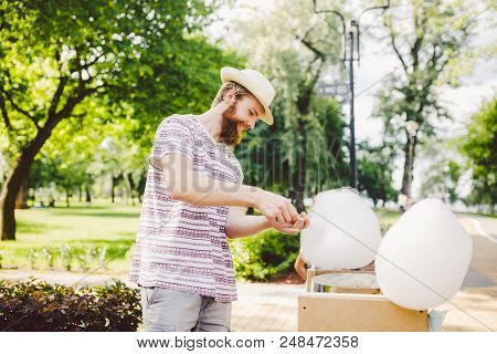 Photo Theme Small Business Cooking Sweets. A Young Man With A Beard Of A Caucasian Trader In The Hat