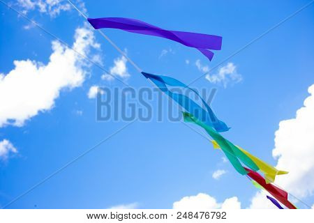 Festive Colorful Ribbon On A Rope On The Background Of Blue Sky