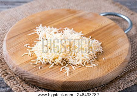 Grated Cheese On A Cutting Board On A Table