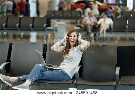 Joyful Traveler Tourist Woman With Headphones Listening Music, Working On Laptop Clinging To Head, W