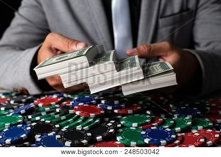 Businessman Holding A Lot Maney On Desk. Casino And Broker Concept.