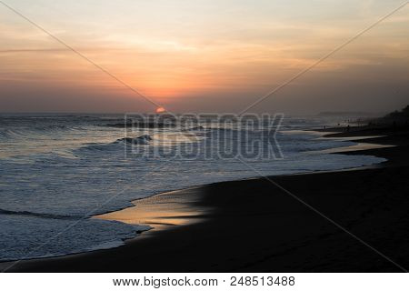 Silhouettes Of People At Sunset On Kuta Beach In Bali, Indonesia