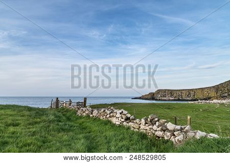 Beautiful Landscape Image Of Dunstanburgh Headland On Northumberland Coast In Late Spring Evening Li