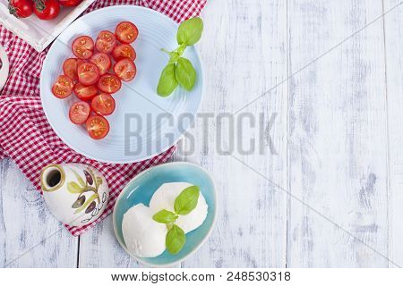 Traditional Italian Salad With Fresh Cherry Tomatoes And Soft Mazarella Cheese, With Basil And Olive
