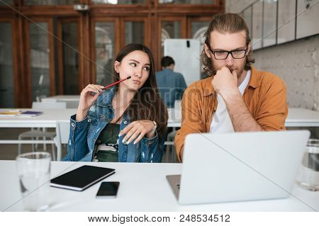 Portrait Of Young Students Sitting In Auditorium And Working With Laptop And Mobile Phone On Table. 