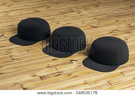 Three Black Blank Snapbacks On The Wooden Floor. 3d Rendering