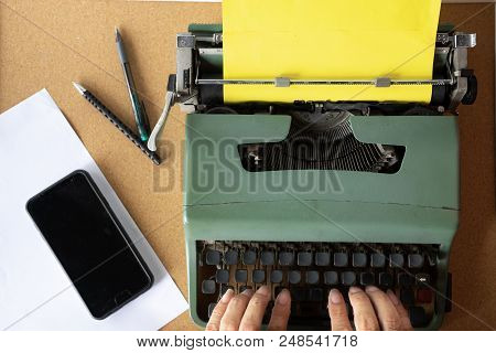 Two Man Hand Typing On Vintage Old Mint Green Thai Typewriter With Plain Yellow  Paper On Crok Woode