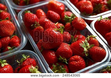 Close Up Of Fresh Red Ripe Strawberries In Transparent Plastic Container Boxes On Retail Market Disp