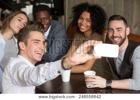Diverse Colleagues Taking Group Photo On Smartphone Spending Time Together In Coffeeshop, Smiling Mu