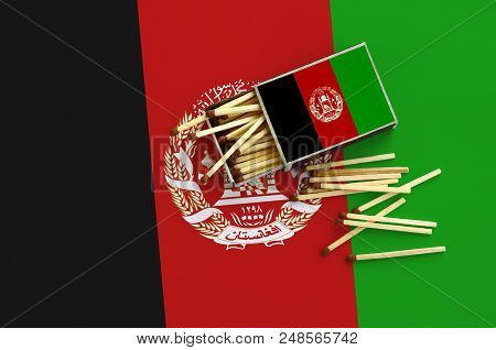 Afghanistan Flag Is Shown On An Open Matchbox, From Which Several Matches Fall And Lies On A Large F
