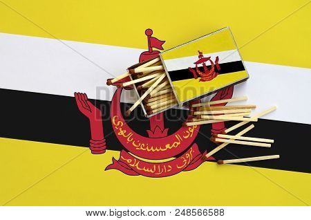 Brunei Darussalam Flag  Is Shown On An Open Matchbox, From Which Several Matches Fall And Lies On A 