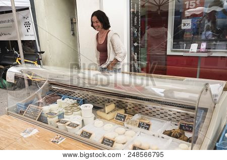 Briancon, France, 10 June 2018: Woman Sells Cheese On Open Air Market Of Briancon In The French Haut