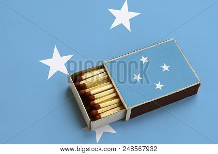 Micronesia Flag  Is Shown In An Open Matchbox, Which Is Filled With Matches And Lies On A Large Flag