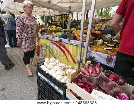 Briancon, France, 10 June 2018: Woman Looks At Vegetables On Open Air Market Of Briancon In The Fren