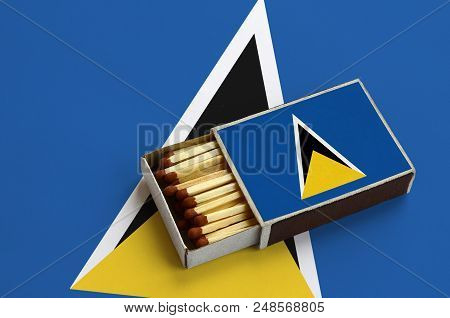 Saint Lucia Flag  Is Shown In An Open Matchbox, Which Is Filled With Matches And Lies On A Large Fla