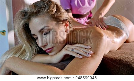 Massage Concept. Portrait Of Beautiful Young Woman Reciving Relxing Massage At Luxury Spa Salon With