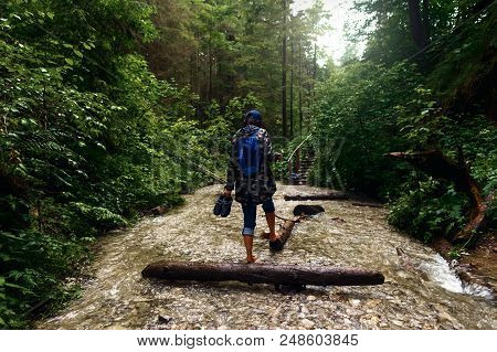 Barefoot Woman With Backpack Walking Dense Forest Along The River. Travel And Backpacking Lifestyle 