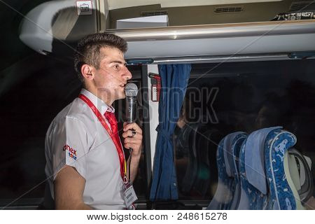 Marmaris, Turkey - May 19, 2018: Male Tour Guide With A Microphone In The Bus In Evening Time