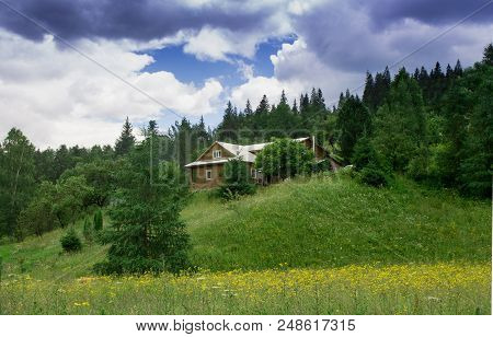 Photo Of Kolyba In Mountain Village In The Summer Under Beautiful Cloudy Sky. Ukraine, Carpathians, 