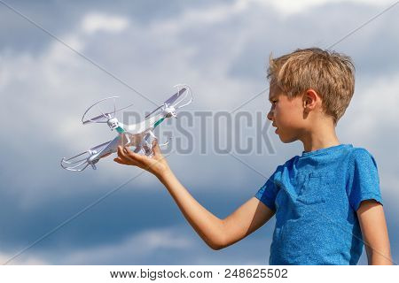 Child Playing With Drone Outdoors Against Blue Sky