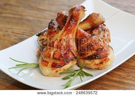 Grilled Chicken Legs With Rosemary Served On White Plate. Dinner Background .