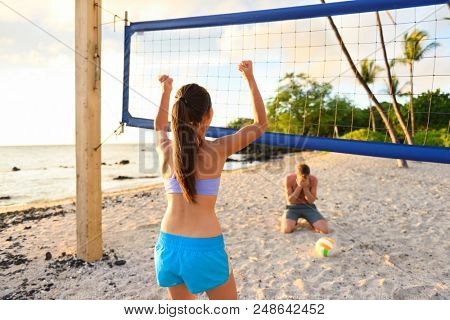 Beach volley ball fun. Girl winning game, man crying. Friends playing beach volleyball sport. Woman living healthy active sport lifestyle. Recreational outdoor game in summer.