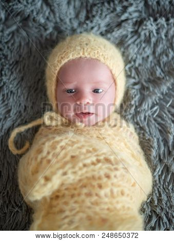 Cute Newborn Baby In A Yellow Hat.