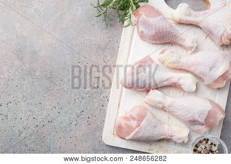 Raw Chicken Legs With Herbs And Spices On Cutting Board. Top View. Gray Background
